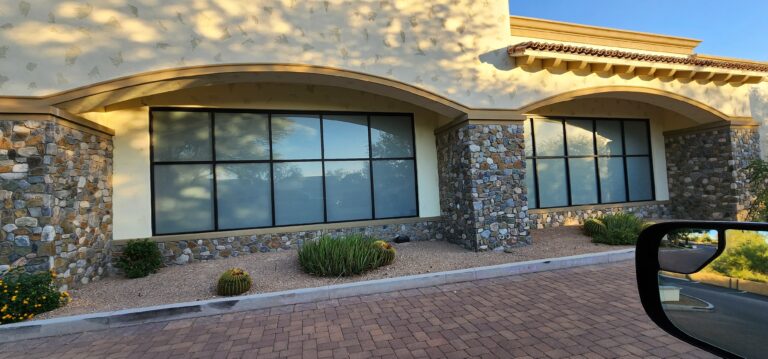 Tinted windows on a stucco and stone building