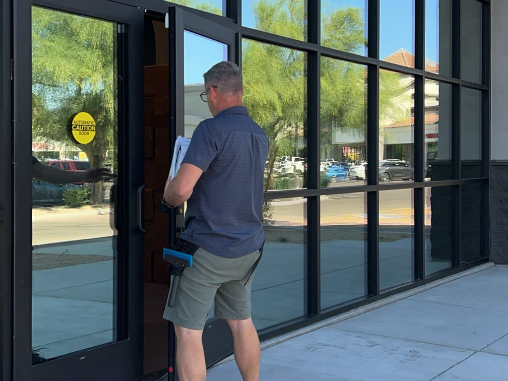 Altered Element installer at a commercial storefront with filmed glass