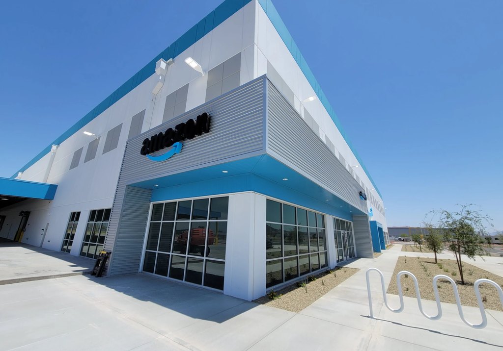 Commercial warehouse building with tinted storefront windows and a blue canopy