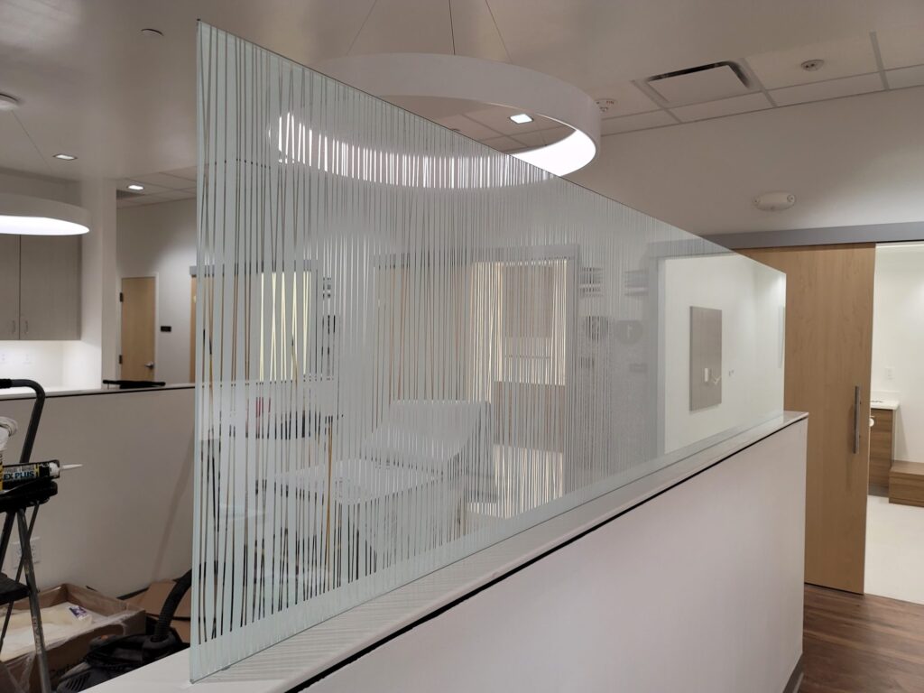 Reception glass with decorative vertical-line film