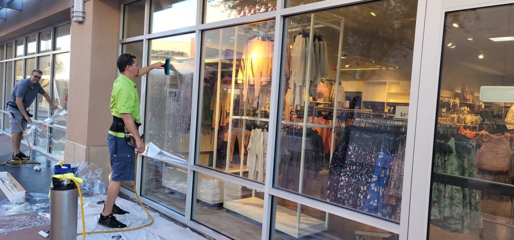 Installer applying safety film to a retail storefront