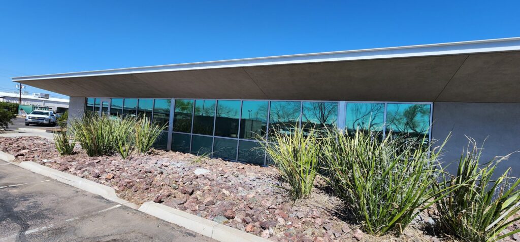 Modern commercial building with solar control film on its glass and desert landscaping