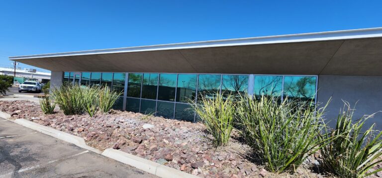 Modern commercial building with solar control film on its glass and desert landscaping
