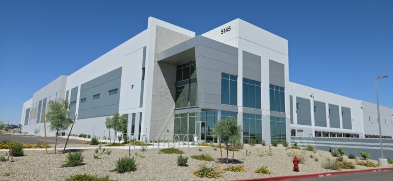 Modern commercial building with tinted windows and desert landscaping