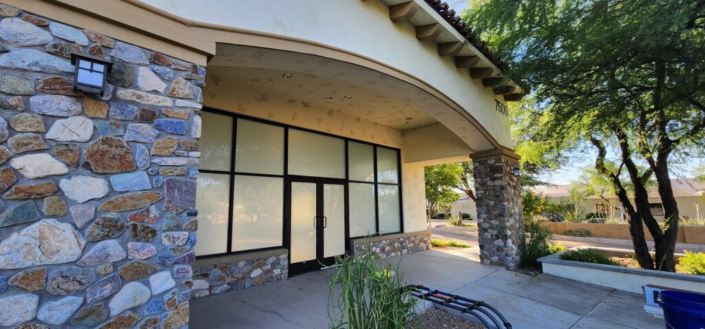 Stone-clad storefront entry with privacy film on the windows